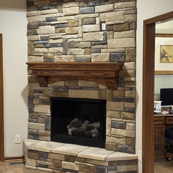 After—multi-tone stacked stone surround with arched wood mantel and direct-vent gas firebox