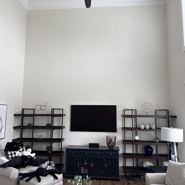 Before—soaring two-story great room with bare wall awaiting a fireplace